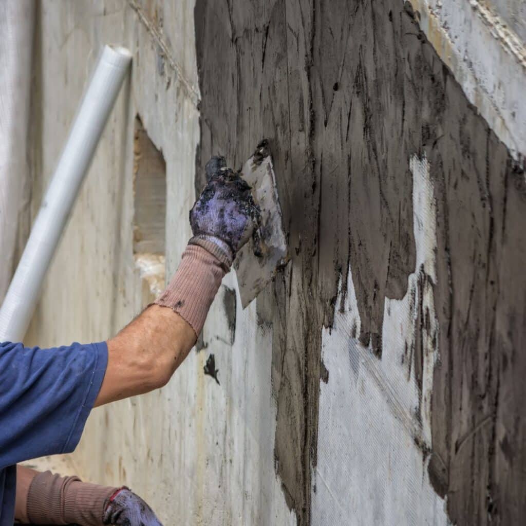 foundation repair expert applying cement over wall