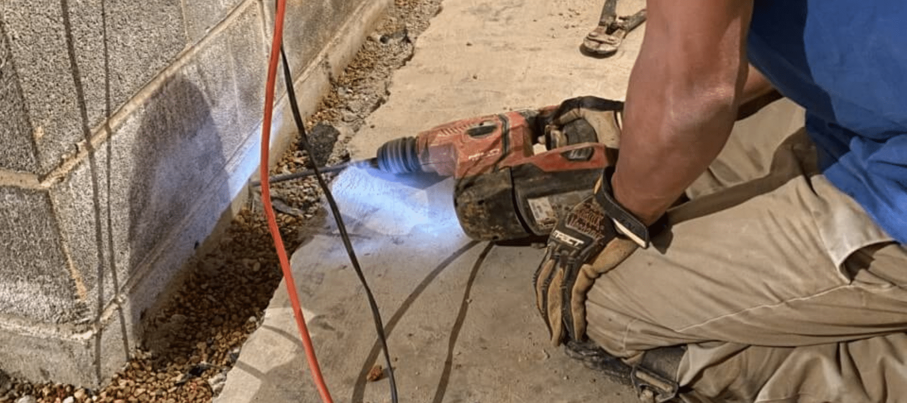 A man drilling a hole in foundation