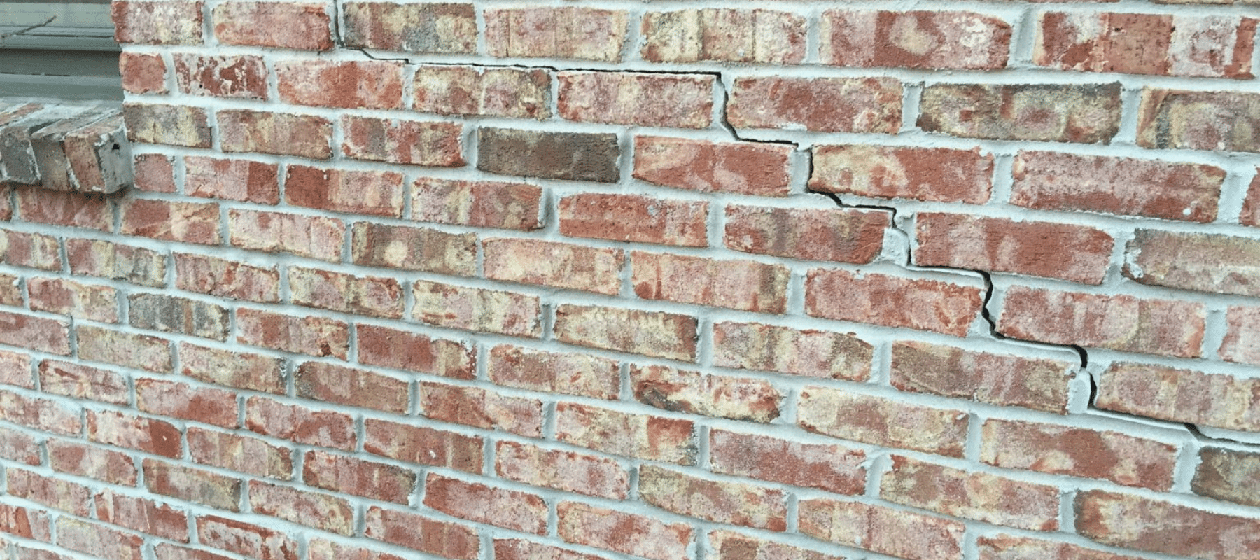 A close up of a brick wall with a crack through it
