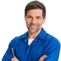 A smiling man in a blue shirt with a wrench
