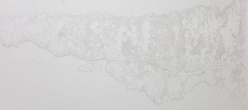 A white wall with water seeping through it.