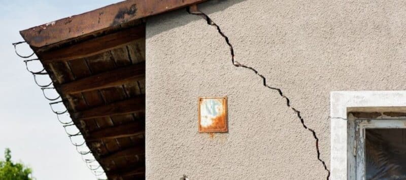 closeup of a large crack on a cement home showing foundation problems