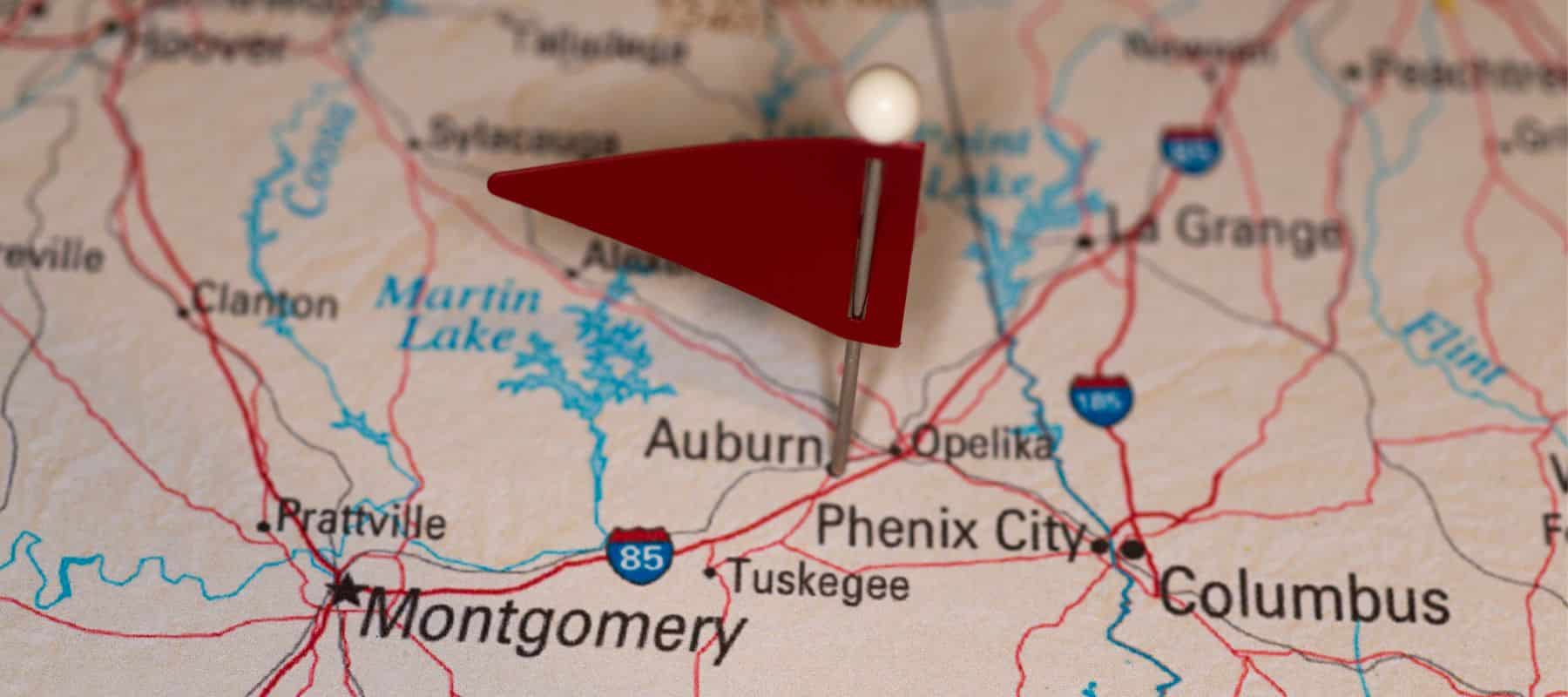 closeup of a map with a red flag pin in it on the city of auburn