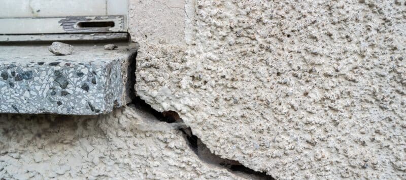 closeup of a large crack in a thick foundation causing structural issues